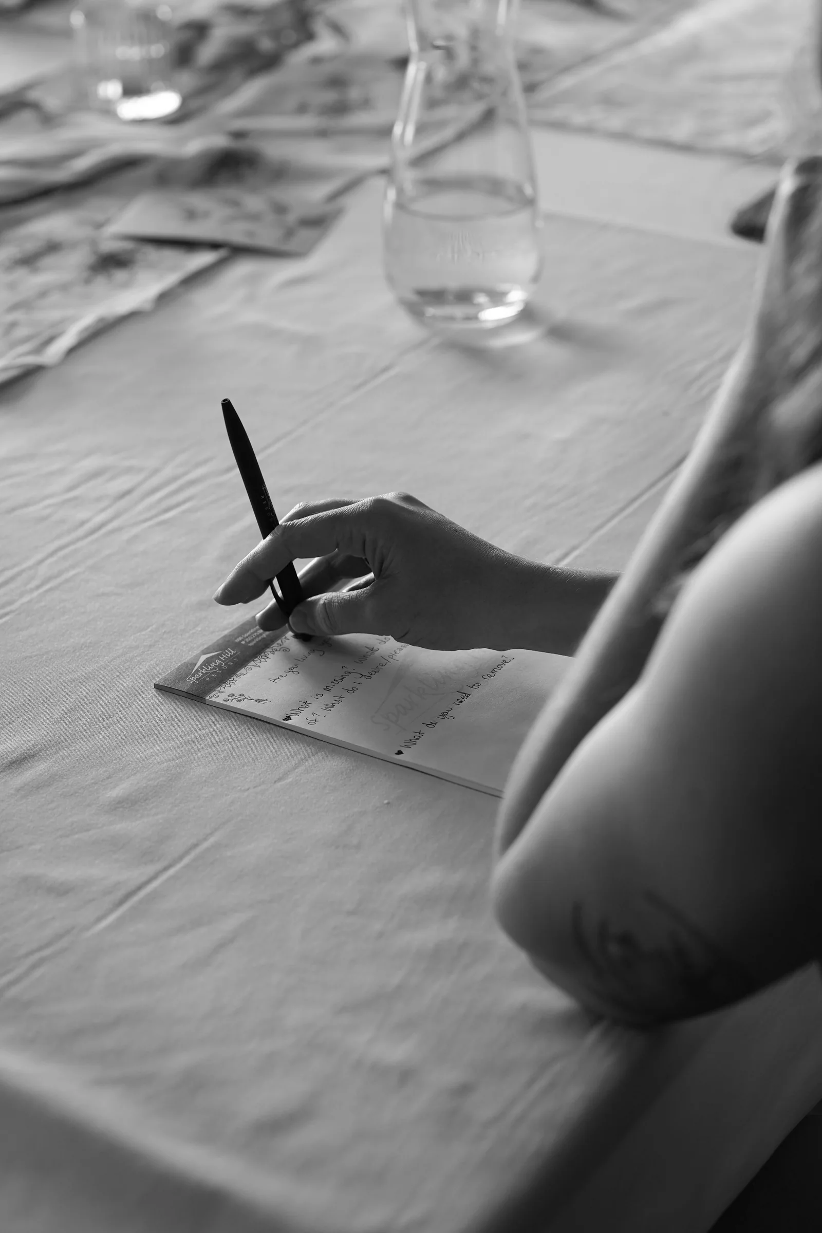 A guest writing in a notebook at a table